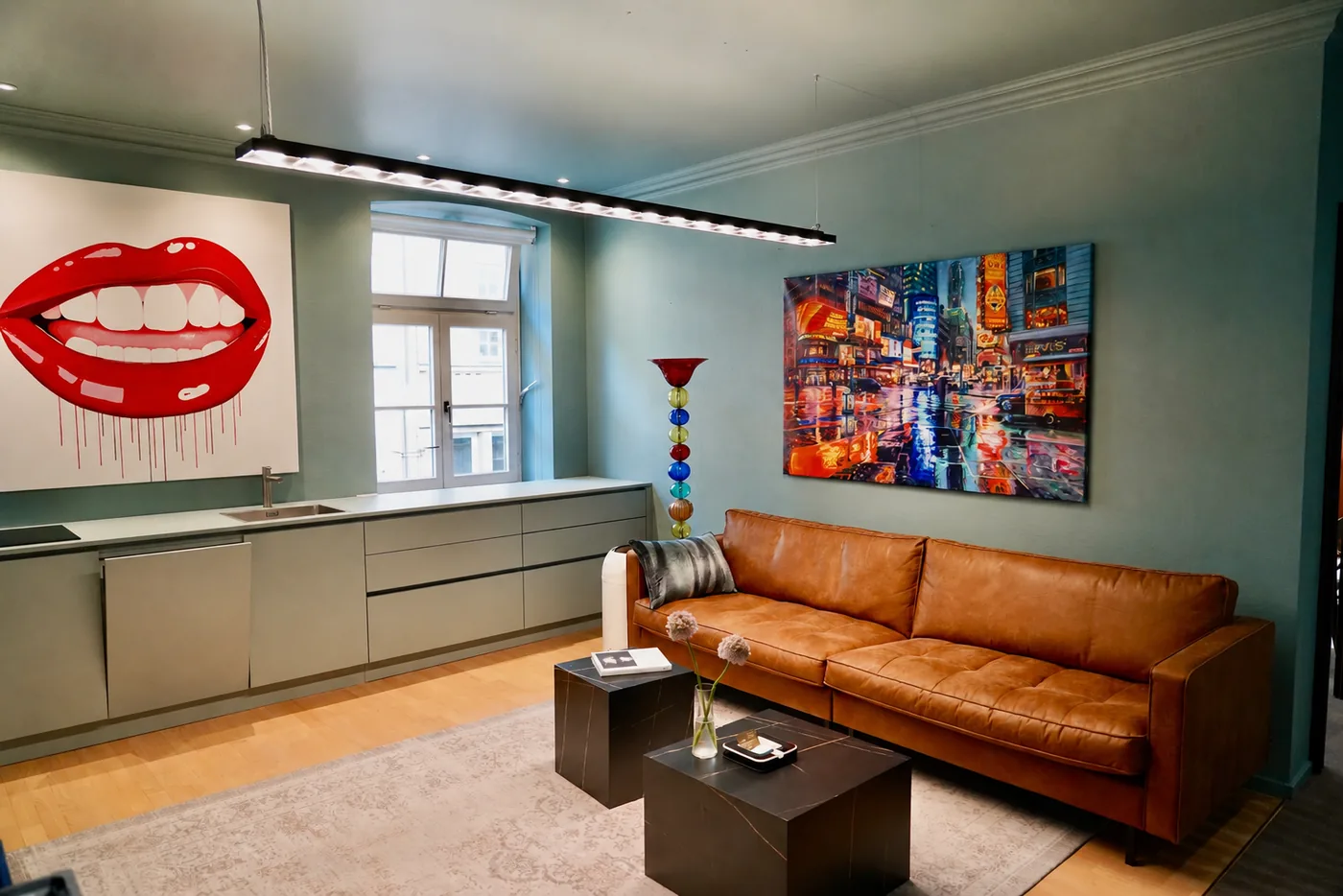 Moderner Küchen- und Loungebereich mit Ledersofa und Kunstwerken